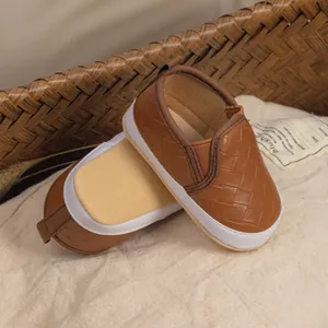 Detailed view of brown woven texture and soft sole on infant slip-on walking shoes
