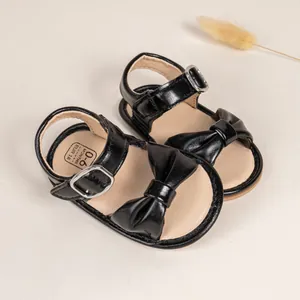 Detail of baby sandal sole showing size 0-6 months and 18 EUR with leather bow and strap