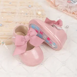Detailed view of pink baby princess shoe with large bow and anti-slip patterned sole