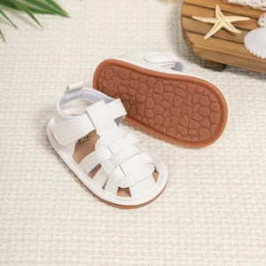 Detail of white infant sandals featuring non-slip pebble sole and velcro strap closure