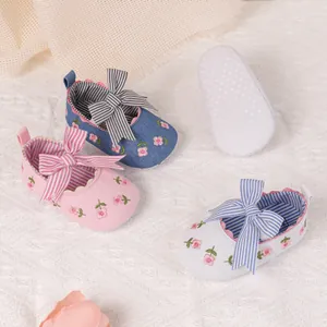 Detailed view of striped bow and flower embroidery on breathable baby soft sole shoes