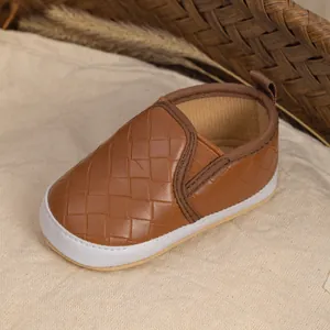 Detailed view of woven brown baby loafer shoes with soft soles and elastic side straps