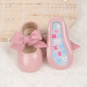 Detailed view of pink baby princess shoes with bow and non-slip rubber soles in size 18