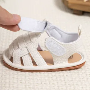 Detail of white leather baby sandals with dual velcro straps and non-slip rubber soles