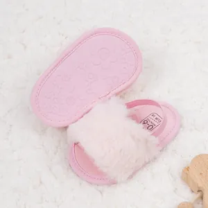 Gros plan de sandales bébé en fausse fourrure rose avec semelles en caoutchouc antidérapantes