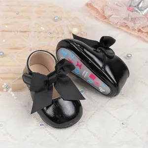 Detail view of baby princess shoes showing black satin bow and non-slip rubber sole