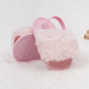 Détail de la sandale en peluche rose pour bébé avec semelle antidérapante et bride élastique