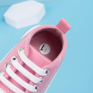Vue détaillée de l'intérieur d'une chaussure bébé en toile rose avec étiquette taille 17