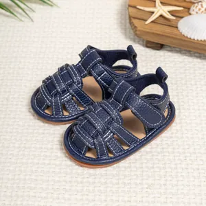 Detail of dark blue baby sandals featuring white stitching and breathable cage design