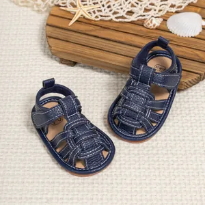 Detailed top view of dark blue baby sandals with woven design on marine decor
