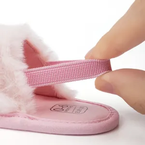 Détail de la sangle élastique des chaussures en peluche rose pour bébé ajustable