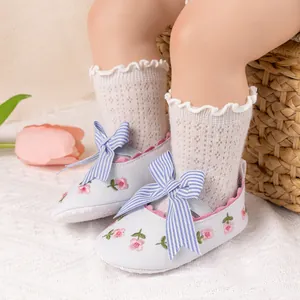 Detail of baby Mary Jane shoe with striped bow and delicate lace socks in a cozy setting