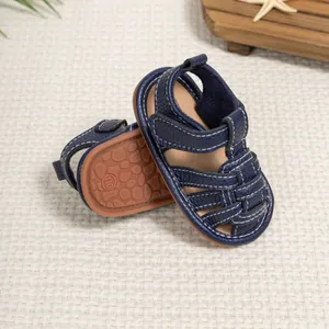Detailed view of dark blue baby sandals with velcro straps and non-slip rubber soles