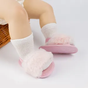 Détail de sandales bébé en fausse fourrure rose avec sangle élastique et semelle antidérapante