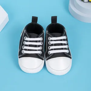 Vue de dessus des chaussures en toile pour bébé noir et blanc avec semelle souple