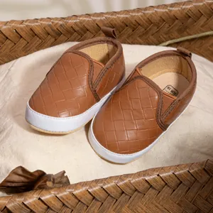 Brown woven baby shoes in a basket, soft-sole slip-on walkers for infants