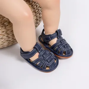 Close-up of navy blue baby sandals featuring woven leather straps and Velcro closure