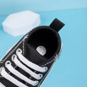 Vue de dessus des baskets hautes en toile pour bébé avec lacets et étiquette de taille