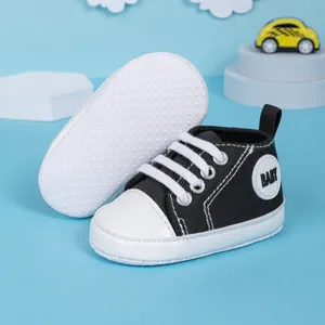 Détail de chaussures bébé en toile avec semelle antidérapante et tige en toile noire