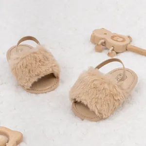 Détail de sandales bébé en peluche avec bride arrière sur fond de tapis blanc doux