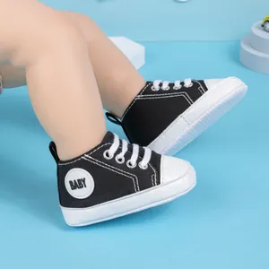 Vue détaillée des chaussures en toile pour bébé avec semelle souple et lacets noirs