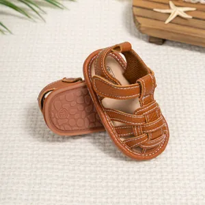 Close-up of brown leather baby sandals featuring non-slip soles and white contrast stitching