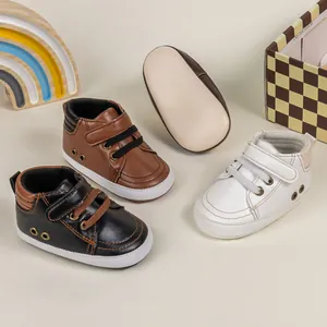 Detail of baby soft-sole walking shoes in black, brown, and white with velcro closure