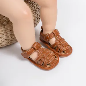 Macro shot of brown leather woven baby sandals with white stitching and velcro closure