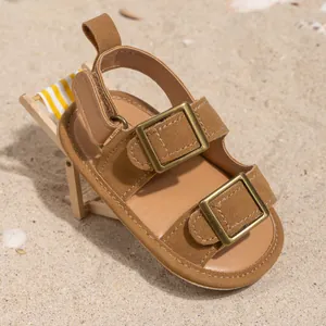Detail of brown baby walker sandals with double buckles on a mini beach chair
