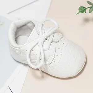 Classic white brogue baby shoes with soft soles and decorative wingtip carving