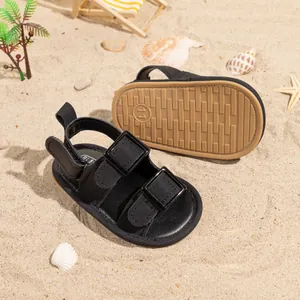 Detail of baby summer sandals featuring black leather straps and anti-slip rubber soles