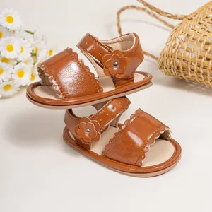 Detailed scalloped trim and leather flower accents on brown infant walking sandals
