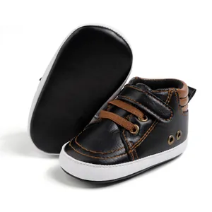 Detail of baby sneakers featuring brown woven laces and white flexible soft sole
