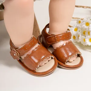 Detail of brown baby sandals featuring cutout edges and floral Velcro strap