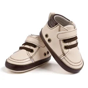 Detail view of baby walking shoes with cream faux leather and brown velcro strap detail