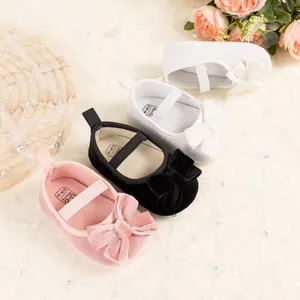 Détail de chaussures de princesse en velours pour bébé avec grands nœuds et rubans élastiques