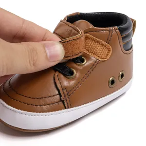 Detail view of baby walking shoe showing brown leather texture and velcro strap closure