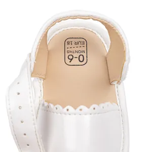 Detail of baby walking sandal showing Velcro strap, white leather and size 18 insole