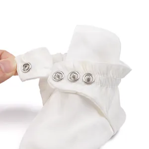 Détail des boutons-pression et de la cheville élastique sur les chaussures de bébé