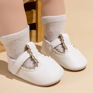 Detailopname van witte PU-lederen Mary Jane babyschoentjes met bijpassende sokken
