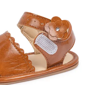 Macro detail of brown baby sandal showing petal layers and white hook-and-loop closure