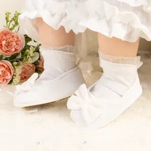 Détails de chaussures pour bébé en velours blanc avec gros nœud et dentelle élégante