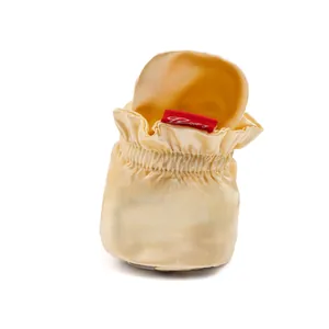 Détail du sac de rangement en satin doré champagne avec cordon élastique et étiquette