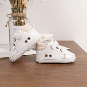 Classic white soft-sole baby walking sneakers with retro metallic eyelets and velcro closure