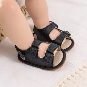 Close-up of black PU leather baby sandals with dual velcro straps and soft rubber soles