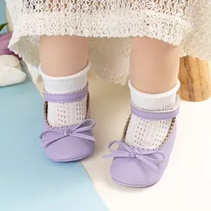 Détail de chaussures Mary Jane violettes pour bébé avec nœud et sangle velcro au pied