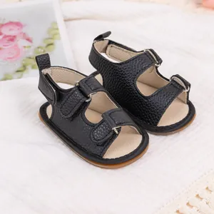 Detail of black pebbled PU leather baby sandals with three adjustable hook and loop straps