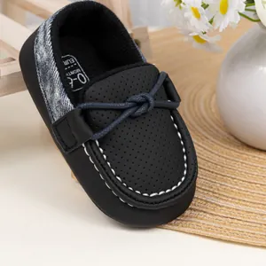 Detailansicht der atmungsaktiven Baby-Loafer mit blauem Knoten und Denim-Patchwork