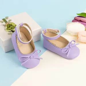 Gros plan de chaussures Mary Jane bébé violettes avec nœud sur boîte cadeau