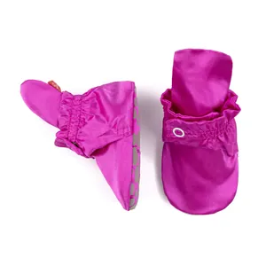 Détail de chaussures bébé en satin fuchsia avec cheville élastique et semelle antidérapante
